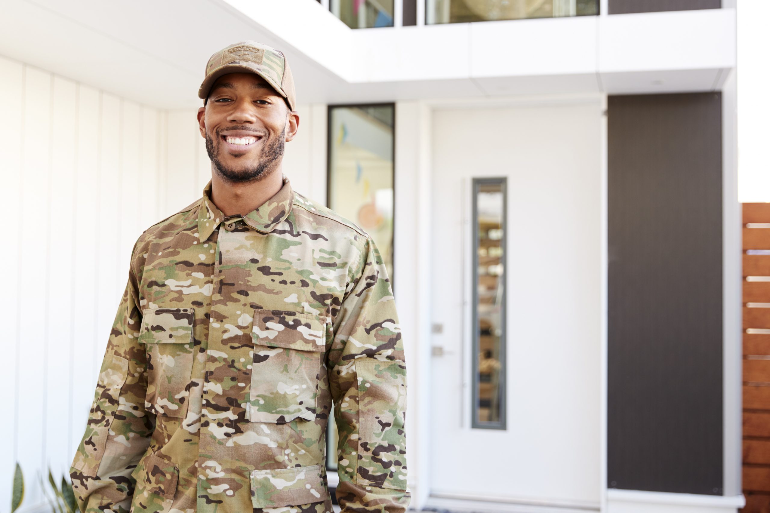 Male wearing camouflage smiling outside an office building